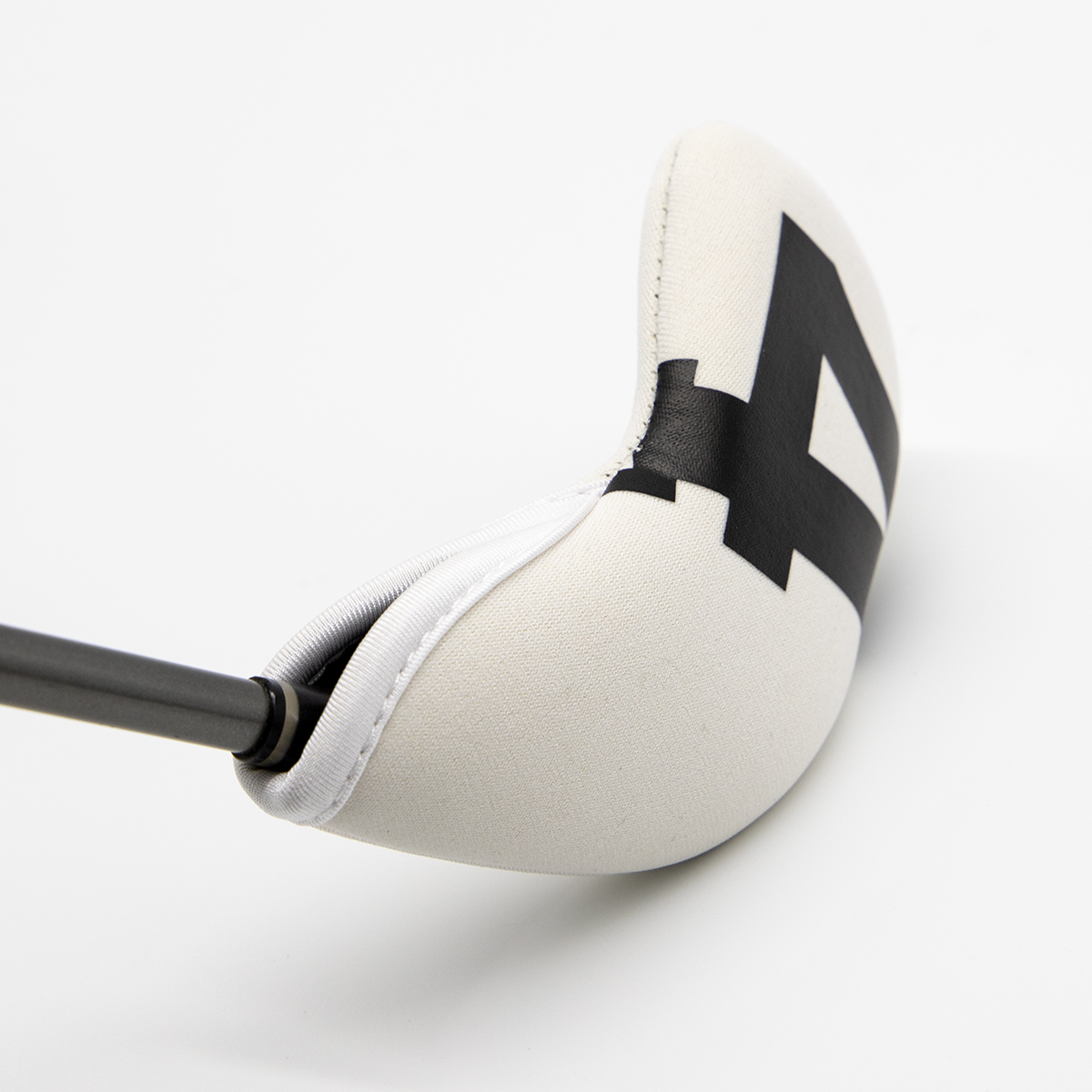 A close-up of a white cover fitted over a club head, with the shaft entering from the left.