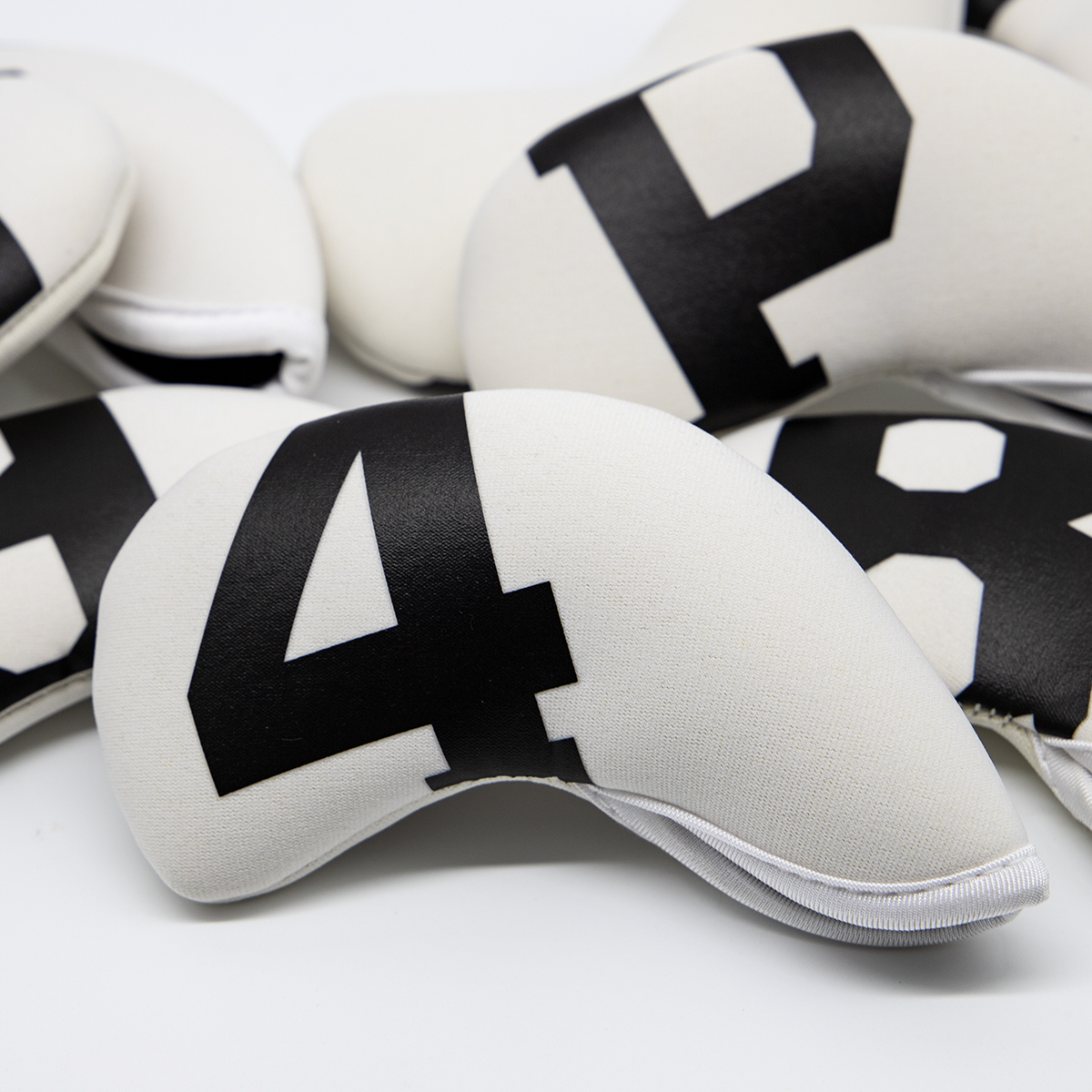 Several overlapping white covers with black numerals and letters are shown close-up.