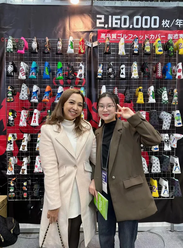 Two people posing in front of a golf-accessory display