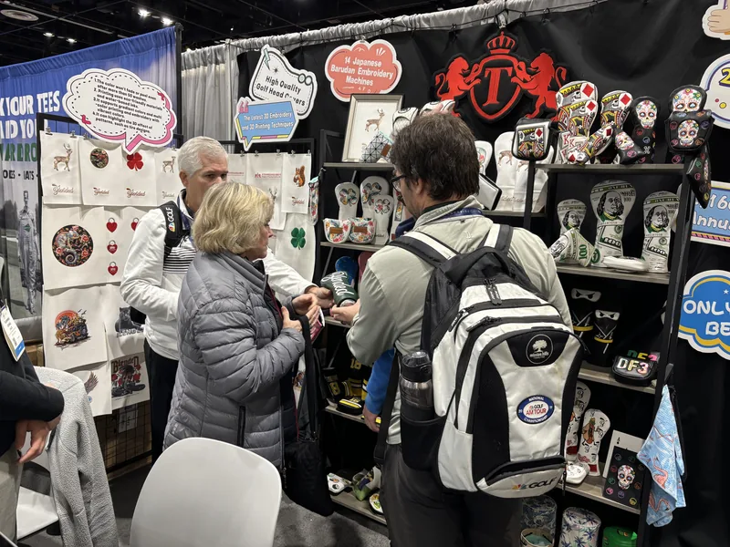 People viewing golf accessories on a merchandise wall