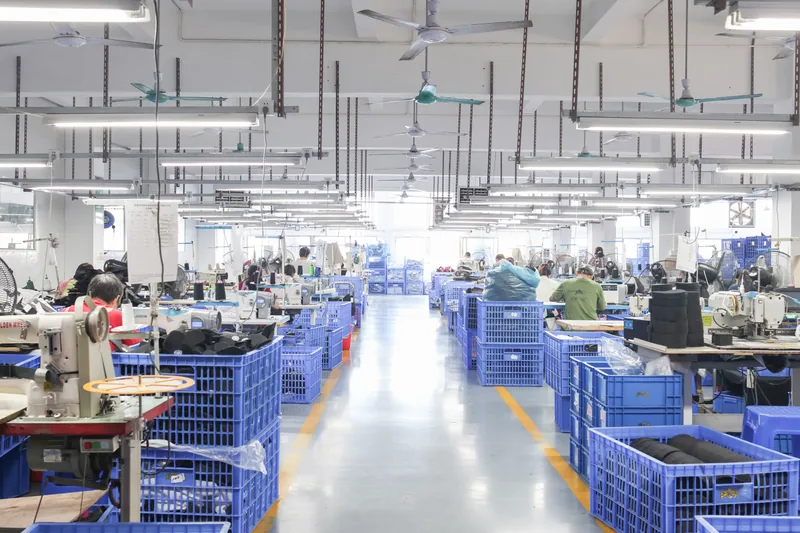 Production-floor aisle with workstations and blue bins