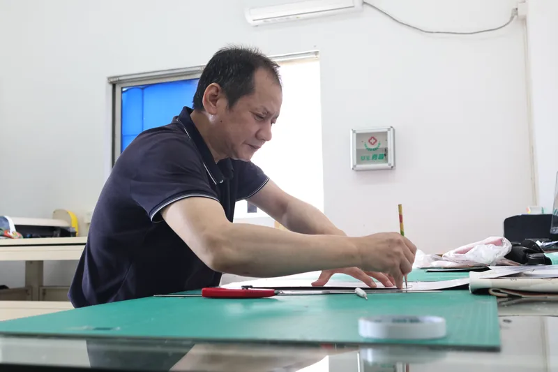 Person cutting material on a green work mat